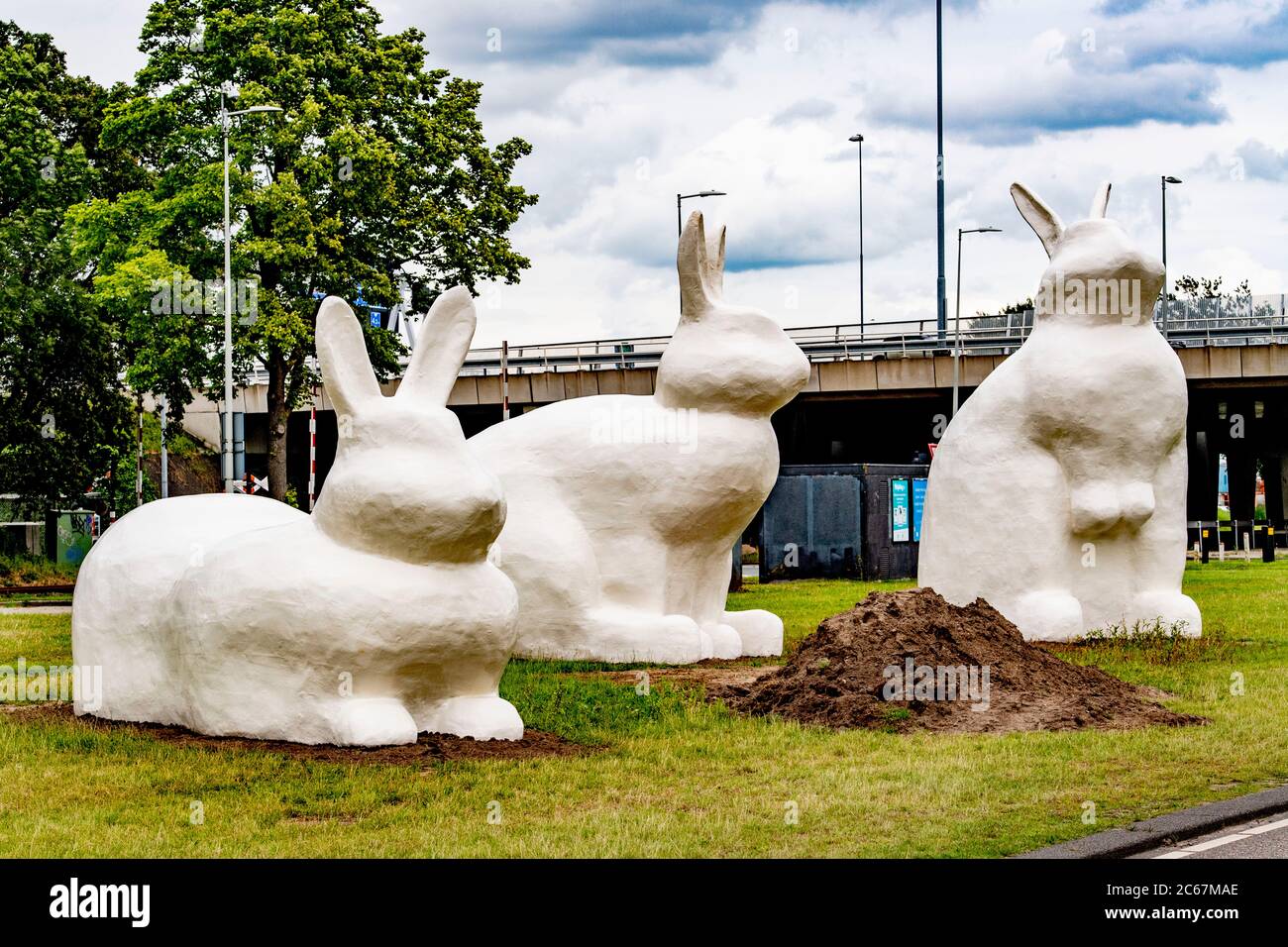 Trois statues géantes de lapins (Berm Bunnies) forment un oeil-de-chat sur la route express de vélo d'Amsterdam à Zaanstad dans la région du port d'Amsterdam. Banque D'Images