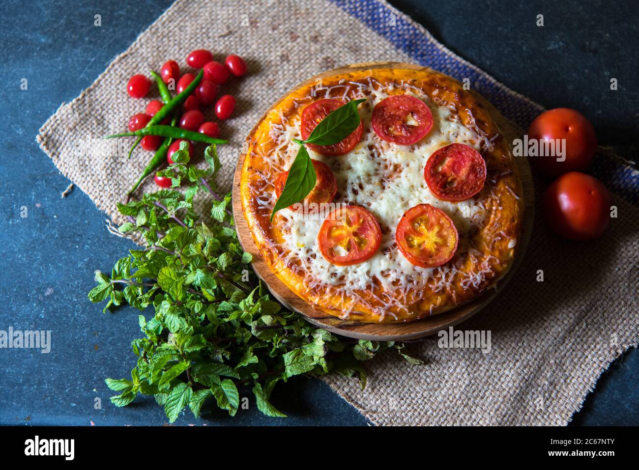 Pizza avec feuilles de menthe et cerises en arrangement sur un fond avec l'utilisation de l'accent sélectif sur un ingrédient particulier Banque D'Images