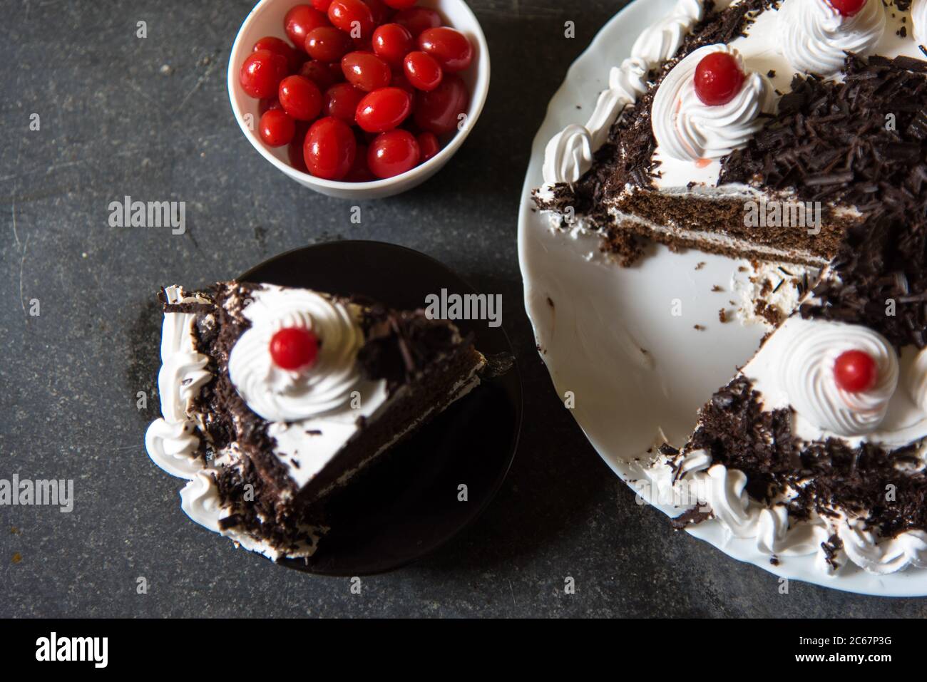 Une tranche de gâteau et de cerises de la forêt noire sur un fond avec l'utilisation de la focalisation sélective Banque D'Images