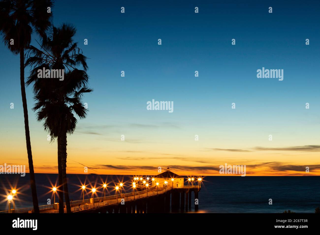Silhouettes de palmiers contre ciel clair et Manhattan Beach Pier, Californie, États-Unis Banque D'Images