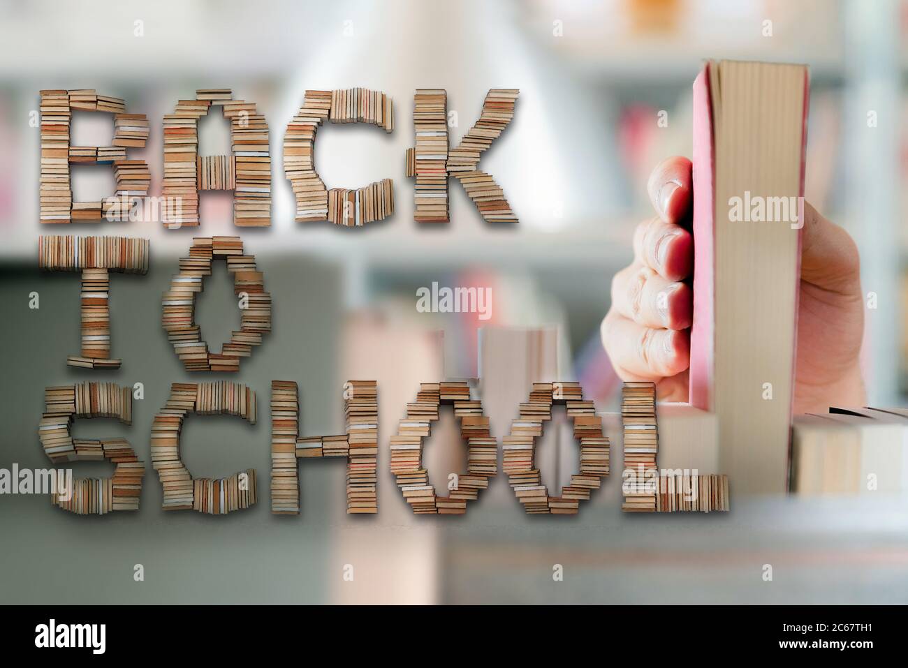 Retour à l'école lettres et jeune étudiant choisir un livre de la tablette dans la bibliothèque en arrière-plan. Banque D'Images