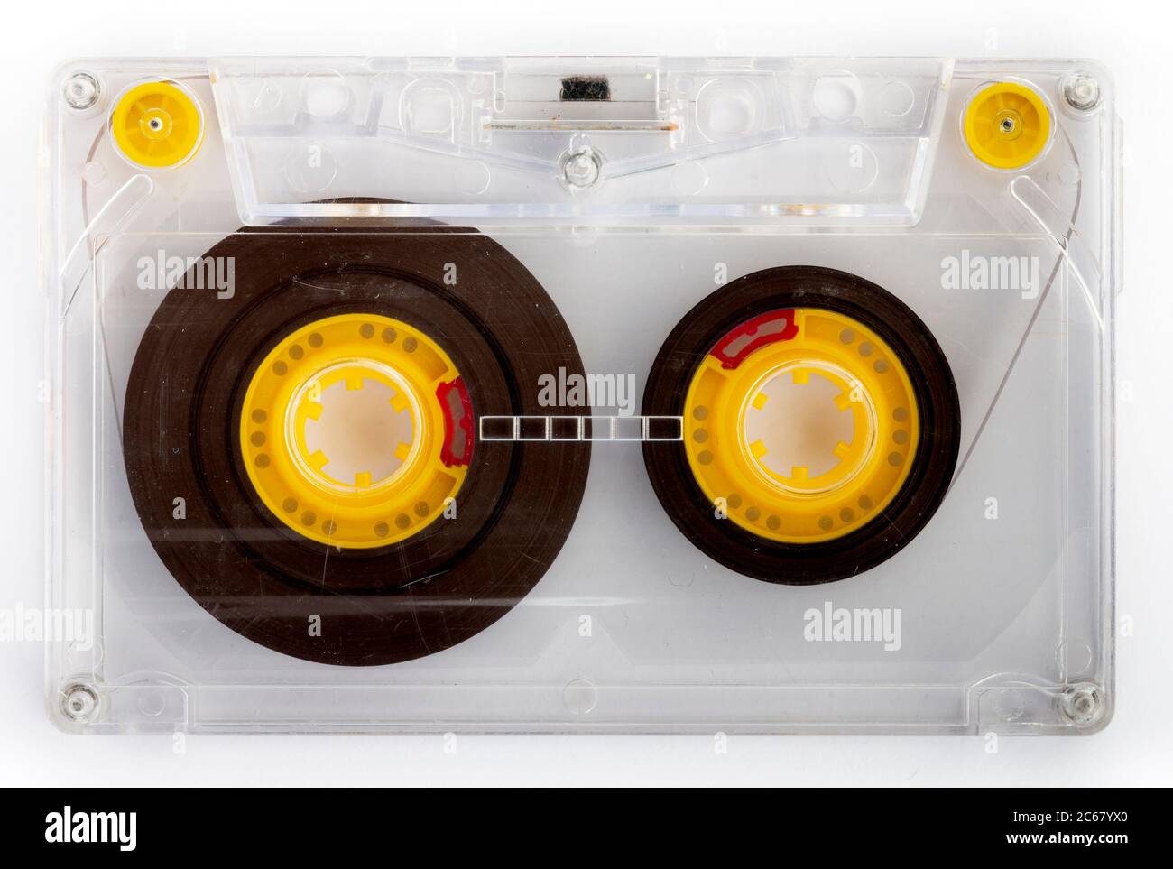 Cassette audio transparente avec rouleaux de cassettes jaunes et guides de cassette sur fond blanc comme concept musical Banque D'Images