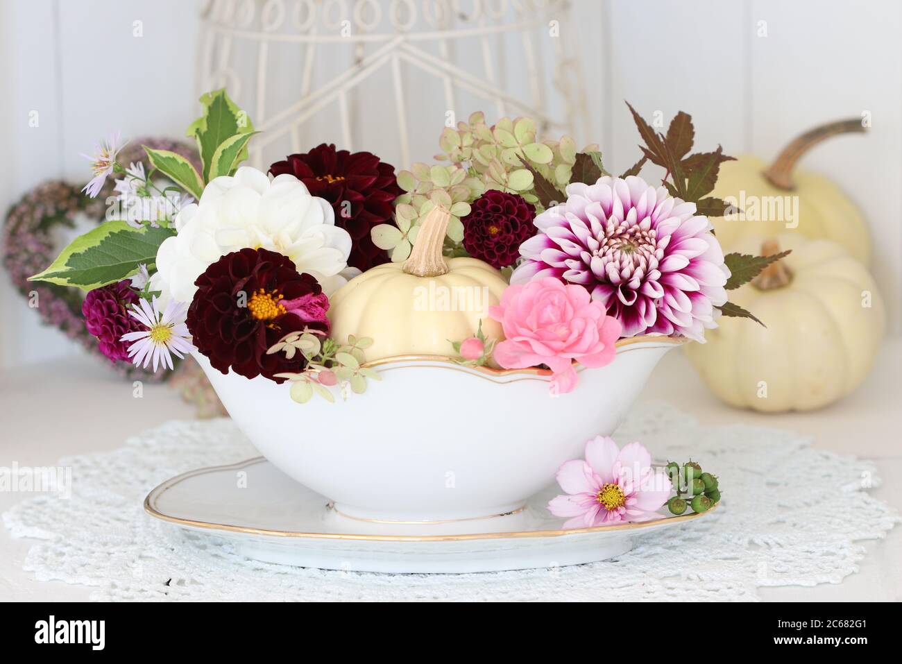 décoration d'automne avec fleurs de dahlia et citrouille blanche d'époque sauce bateau Banque D'Images