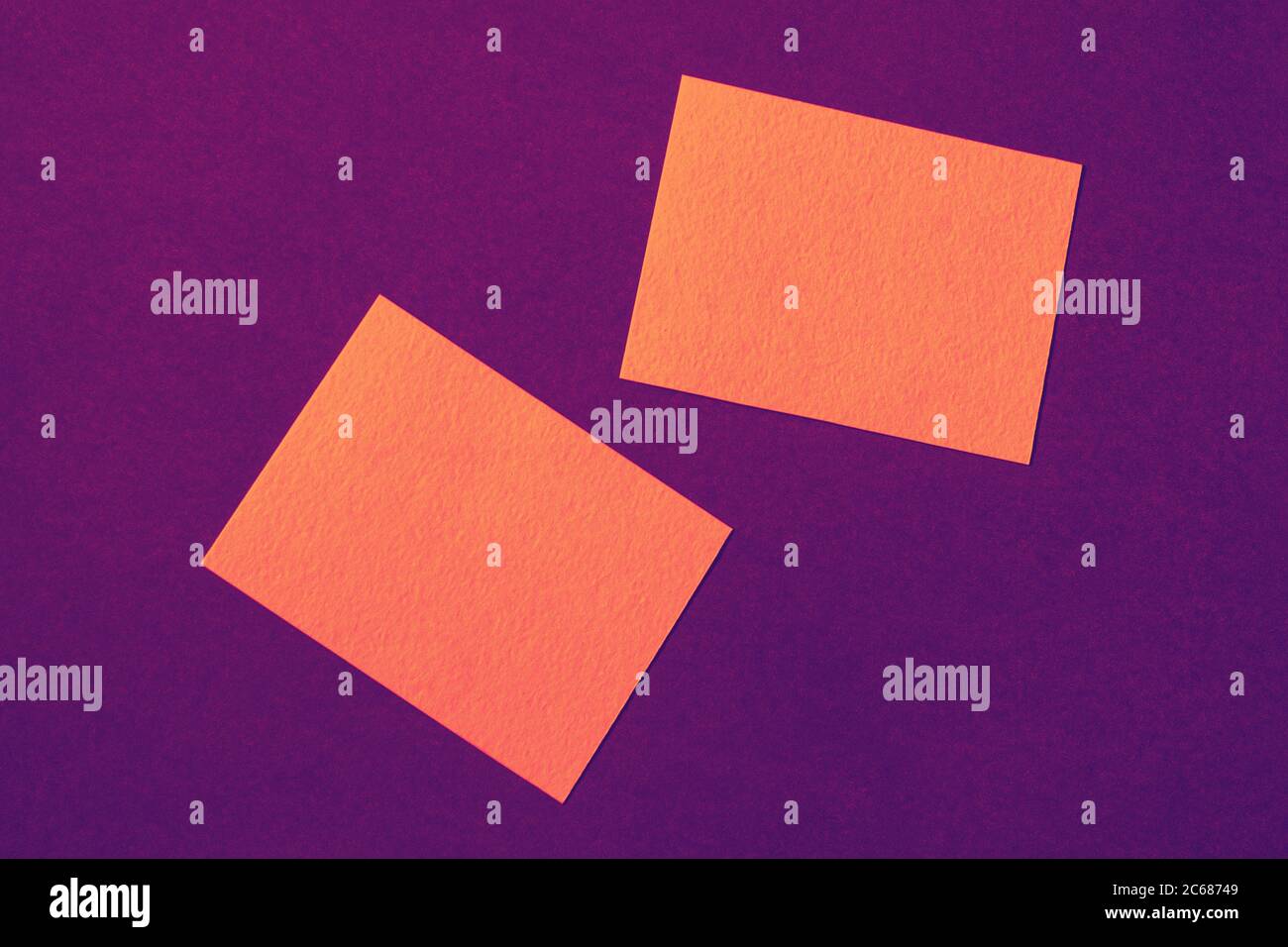 cartes en papier orange sur fond violet disposées de manière aléatoire, publicité en couleurs vives intenses et vives Banque D'Images