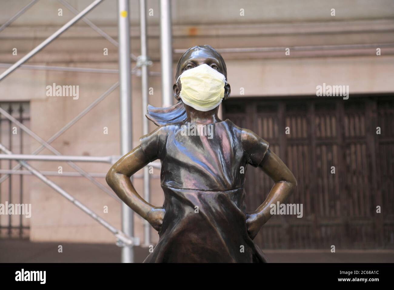 Statue de la fille redoutable portant un masque chirurgical devant la Bourse de New York pendant la pandémie COVID-19, Manhattan New York City, Etats-Unis Banque D'Images