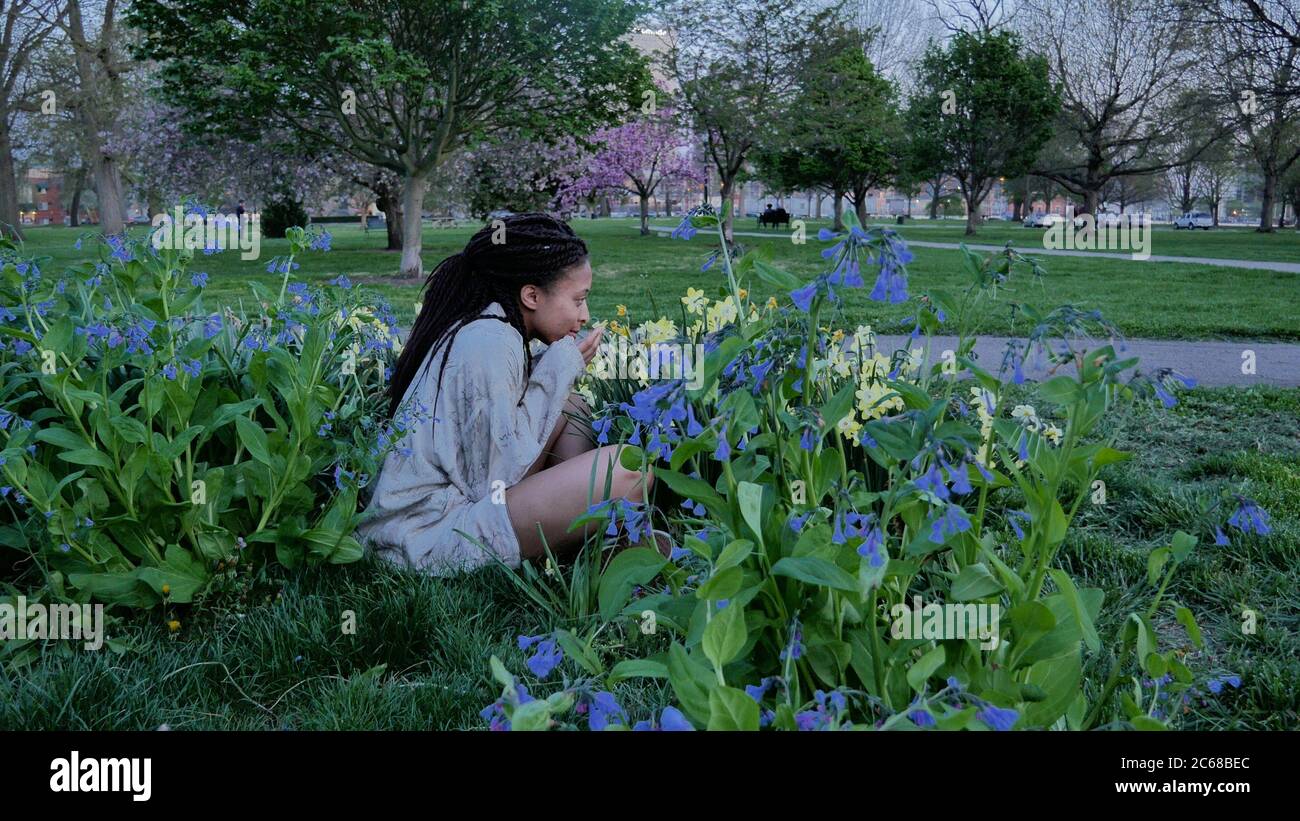 femme assise dans un beau lit de fleurs Banque D'Images