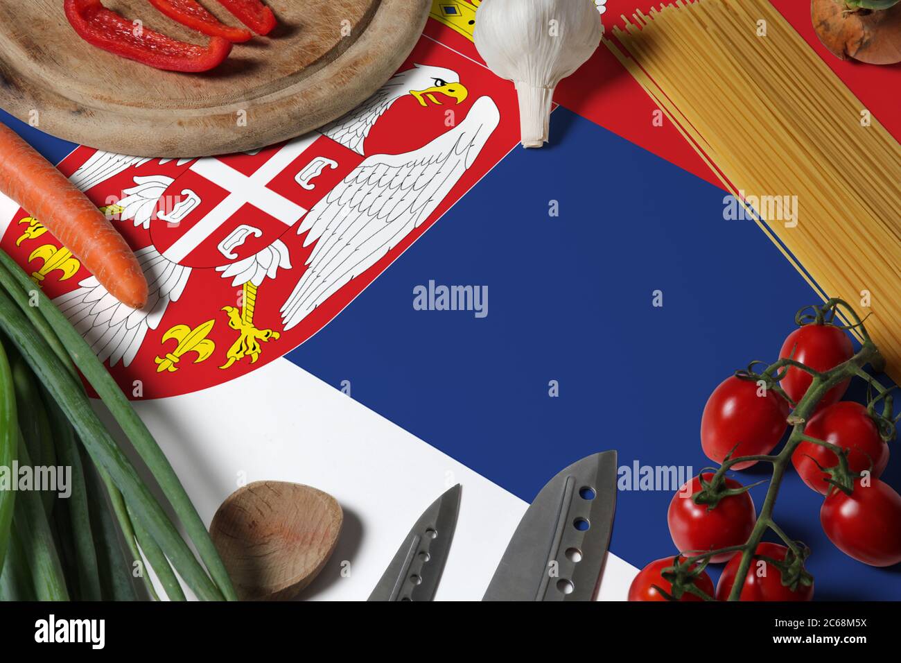 Drapeau de Serbie sur les légumes frais et couteau concept table en bois. Concept de cuisine avec thème de préparation. Banque D'Images