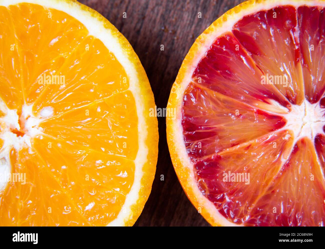 Deux tranches de sang orange et orange sur fond de bois Banque D'Images