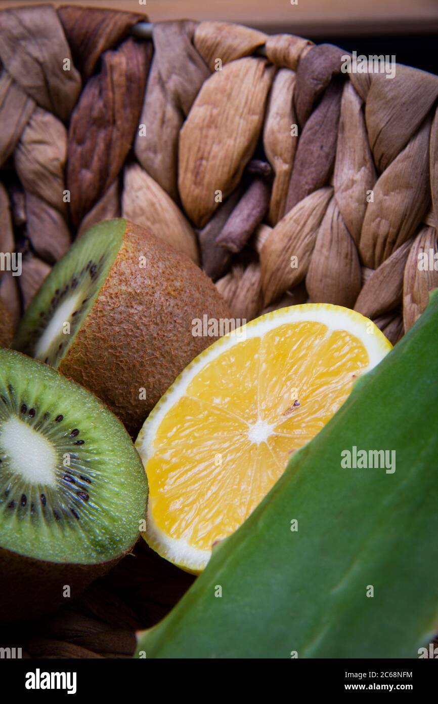 Kiwi et citron aigre et une feuille d'aloe vera dans un panier en bois. Banque D'Images