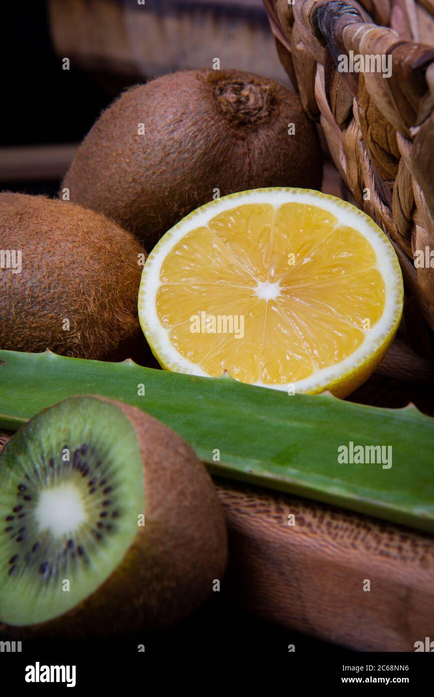 Kiwi et citron aigre et une feuille d'aloe vera dans un panier en bois. Banque D'Images