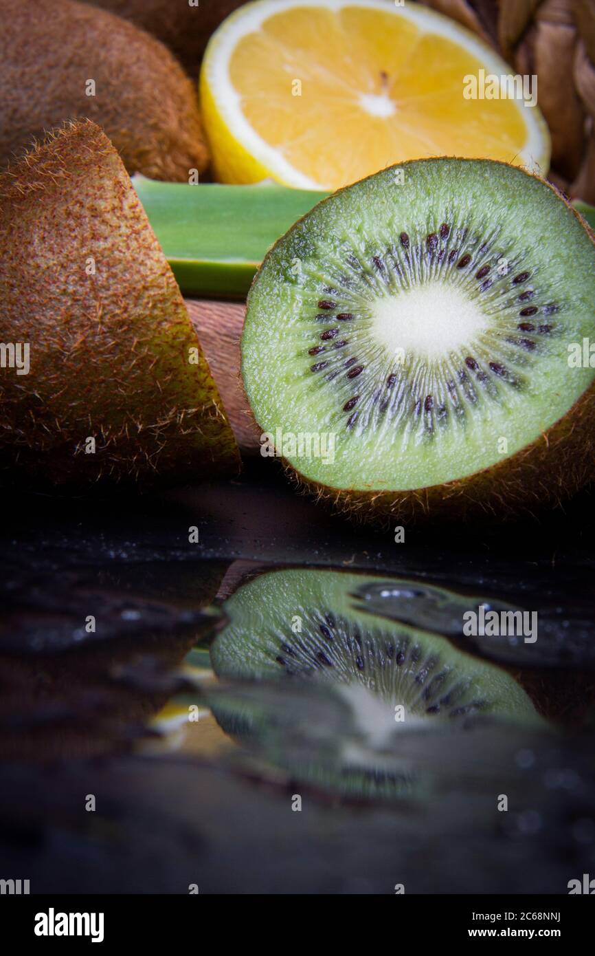 Kiwi et citron aigre et une feuille d'aloe vera dans un panier en bois. Banque D'Images