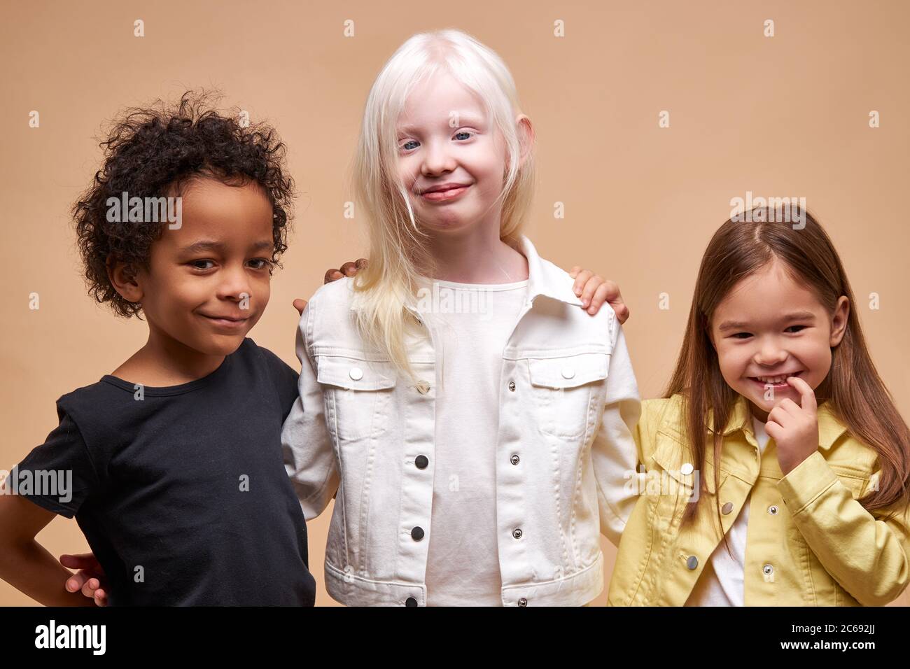 divers souriants positifs enfants posant à la caméra, heureux garçon à la peau sombre et albino, les filles caucasiennes heureux ensemble, amitié internationale étroite. Banque D'Images