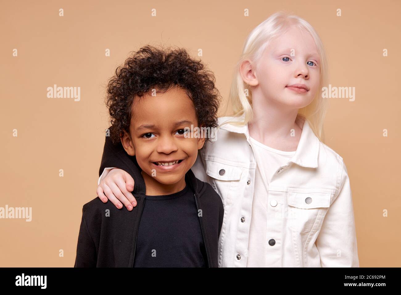 une amitié étroite entre deux enfants de différentes nationalités, belle albinos caucasienne fille et un garçon africain à la peau sombre avec des cheveux bouclés, ils un Banque D'Images