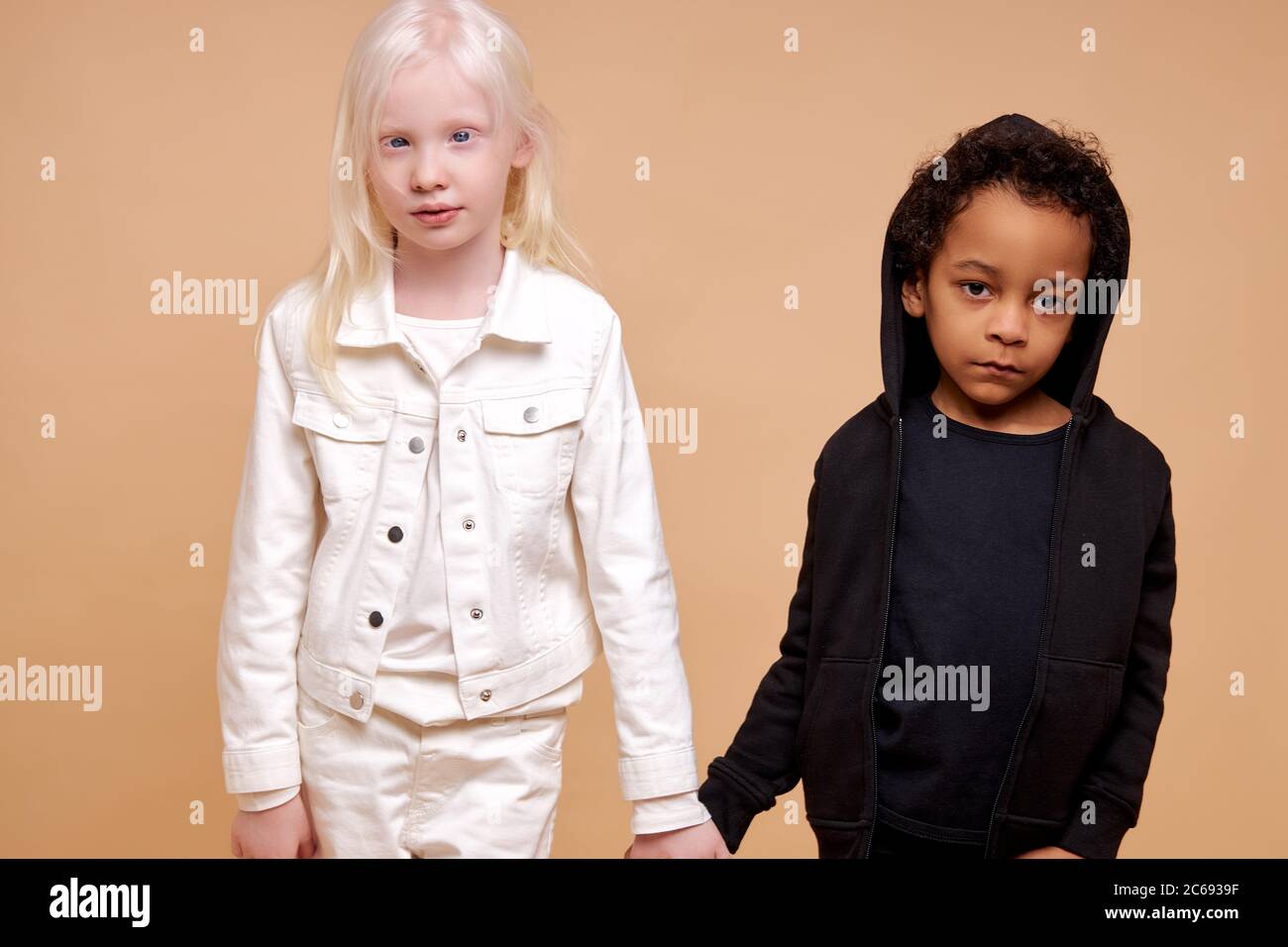 portrait d'enfants amicaux divers posant à la caméra isolé, adorable africanamerican et albinos enfants ont l'amitié internationale, ils tiennent han Banque D'Images