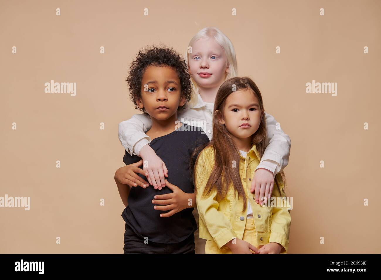 portrait d'adorables enfants divers isolés. afro-américains, albinos et européens se tiennent ensemble, l'amitié étroite entre eux. les gens plongent Banque D'Images