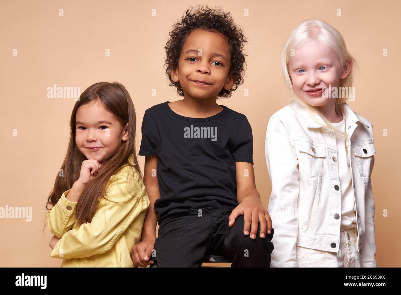 divers souriants positifs enfants posant à la caméra, heureux noir garçon et albino, caucasiens filles heureux ensemble, étroite amitié internationale. isolat Banque D'Images