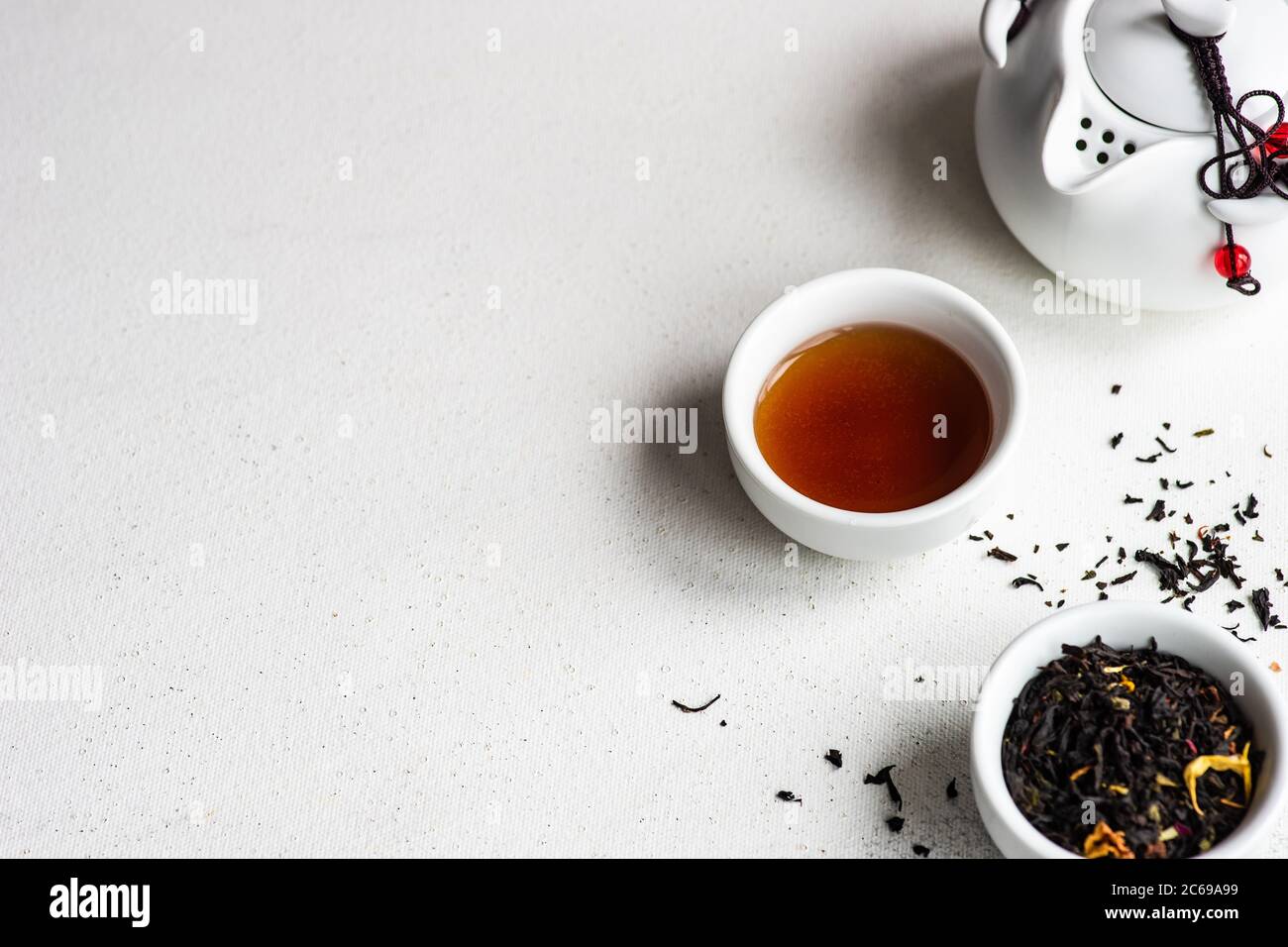 Tasse de thé avec feuilles de thé et une théière Banque D'Images