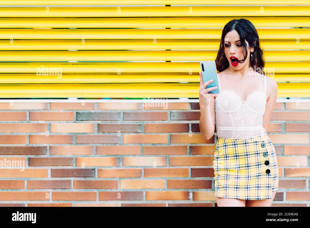 portrait d'une femme à bouche ouverte regardant le smartphone Banque D'Images
