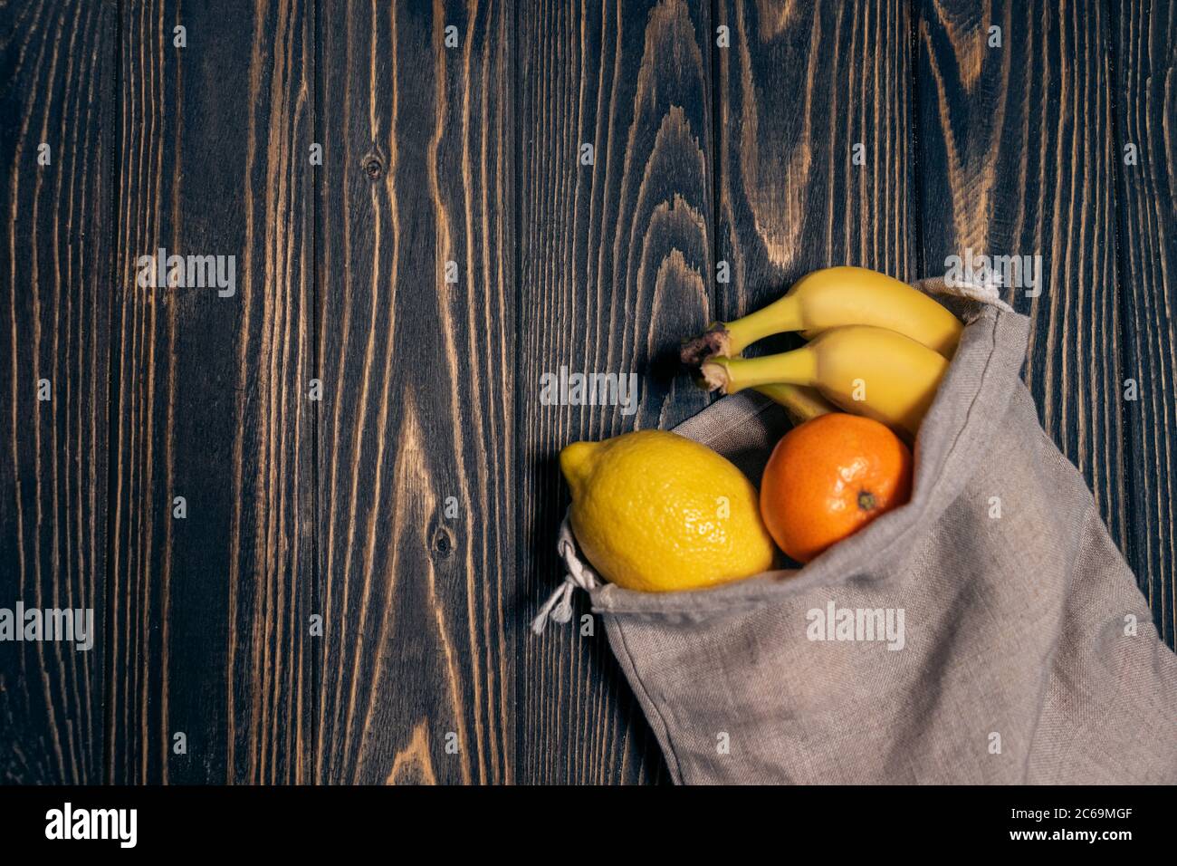 fruits frais dans des sacs écologiques recyclables sur une table en bois, vue du dessus Banque D'Images