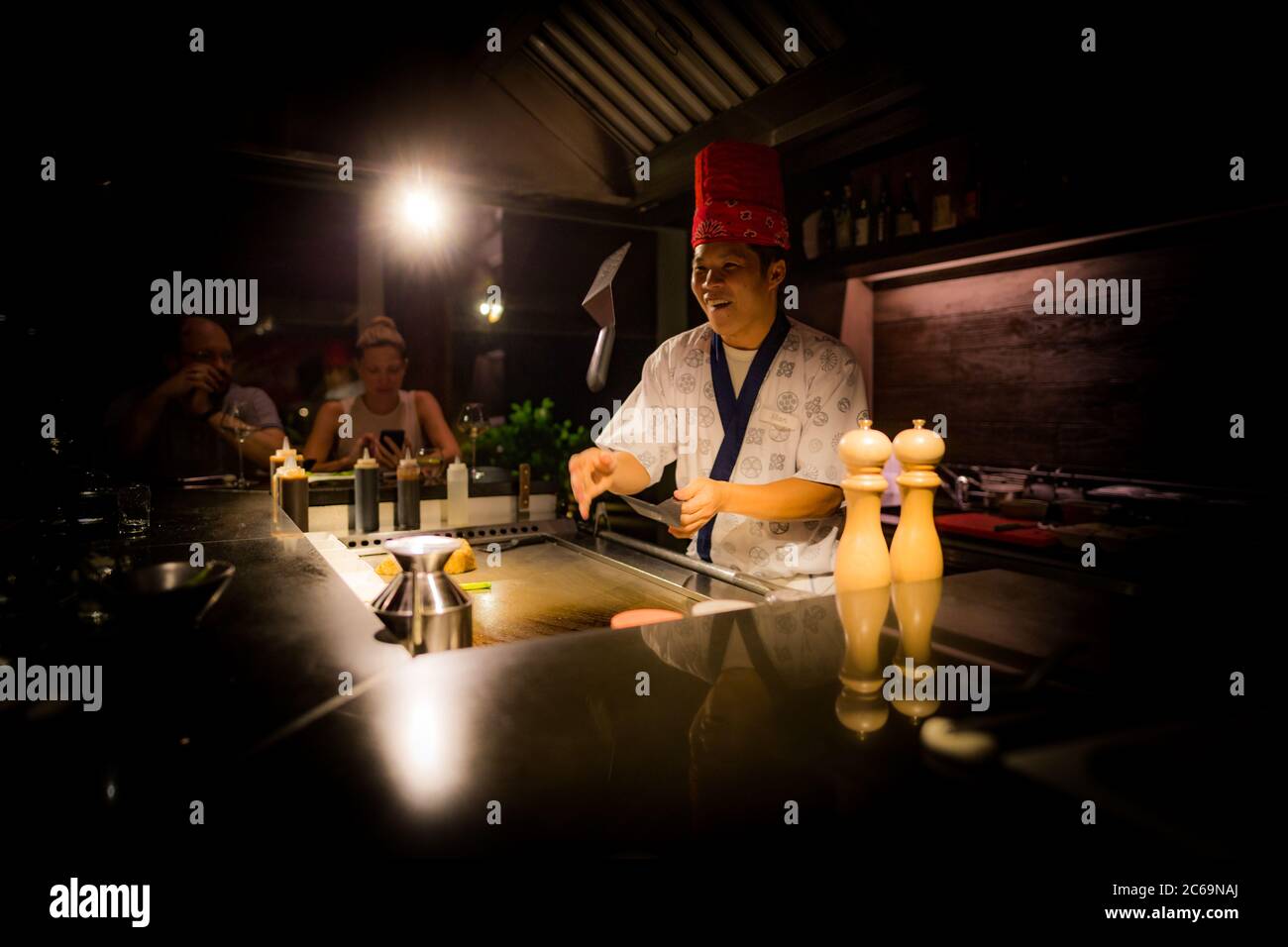 Mai, 2018 - Ari Atoll, Maldives: Happy teppanyaki chef cuisant des légumes teppan dans la steakhouse japonaise sur Mishi Sushi. Restaurant gastronomique de luxe Banque D'Images