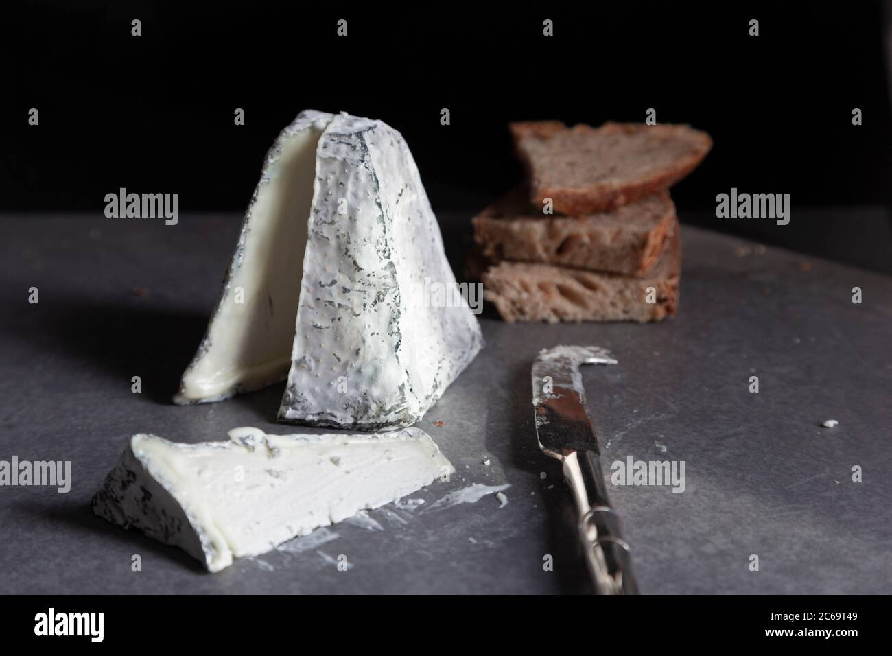Une pyramide de fromage de chèvre recouverte de cendre avec pain grillé au levain Banque D'Images
