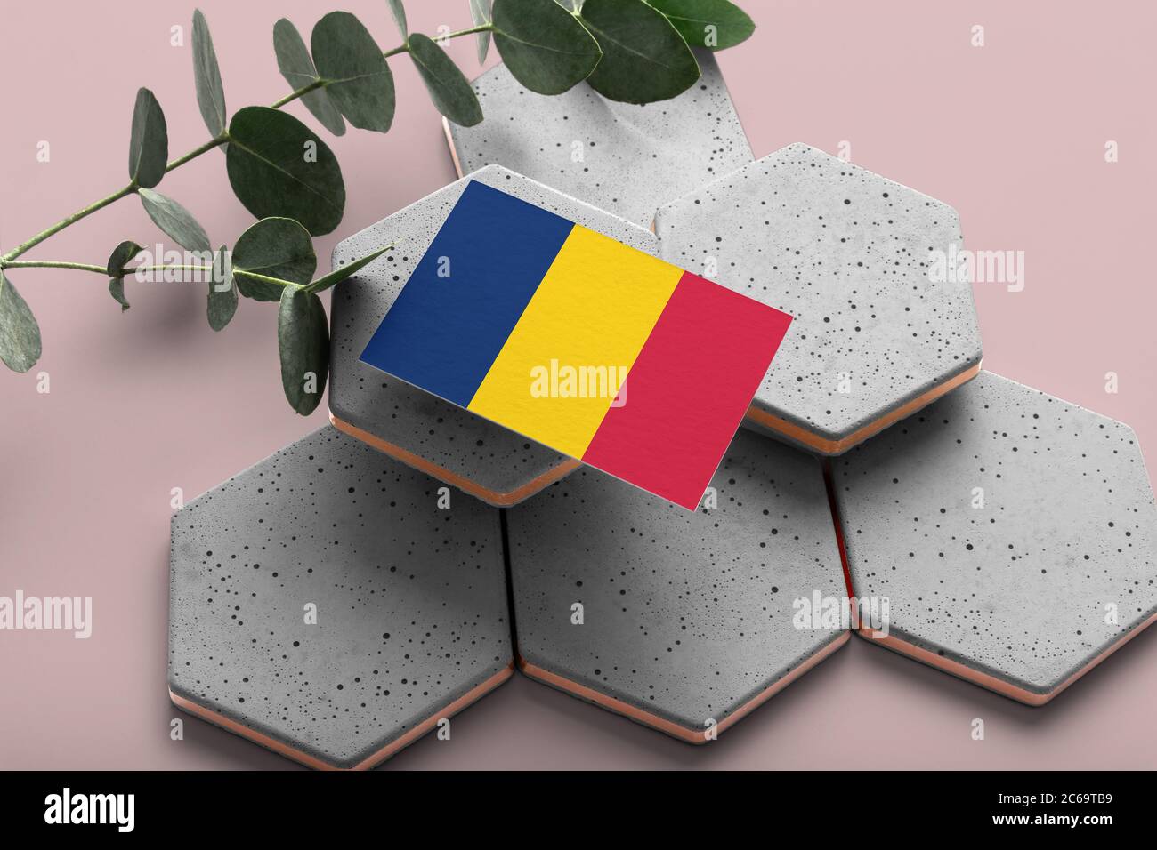Drapeau tchadien sur pierres élégantes hexagonales. Arrière-plan rose de l'espace de copie. Flat Lay, vue de dessus concept national minimal. Banque D'Images
