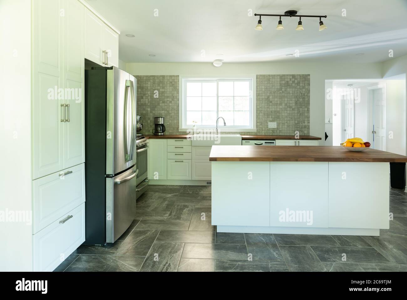 Nouvelle cuisine grise et blanche avec appareils électroménagers et plan de travail en bois Banque D'Images