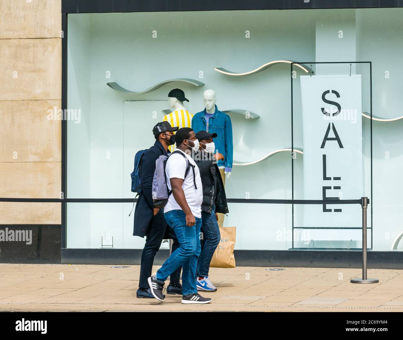 Edimbourg, Écosse, Royaume-Uni, 8 juillet 2020. Les masques faciaux sont la norme sur Princes Street, avec de plus en plus de gens qui les portent, surtout pour aller dans les magasins, bien qu'ils ne deviennent obligatoires dans les magasins en Écosse que vendredi. Un groupe d'hommes noirs portant des masques de visage marchant devant Zara magasin de vêtements fenêtre de vente Banque D'Images