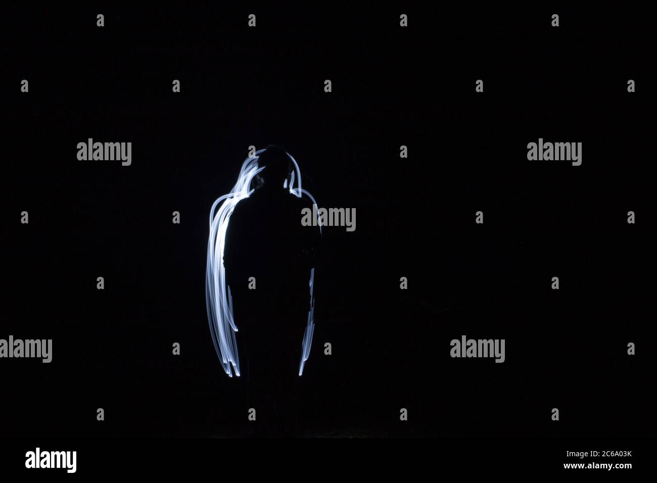 Lampe de poche dans la silhouette sombre et peinte par la lumière Banque D'Images