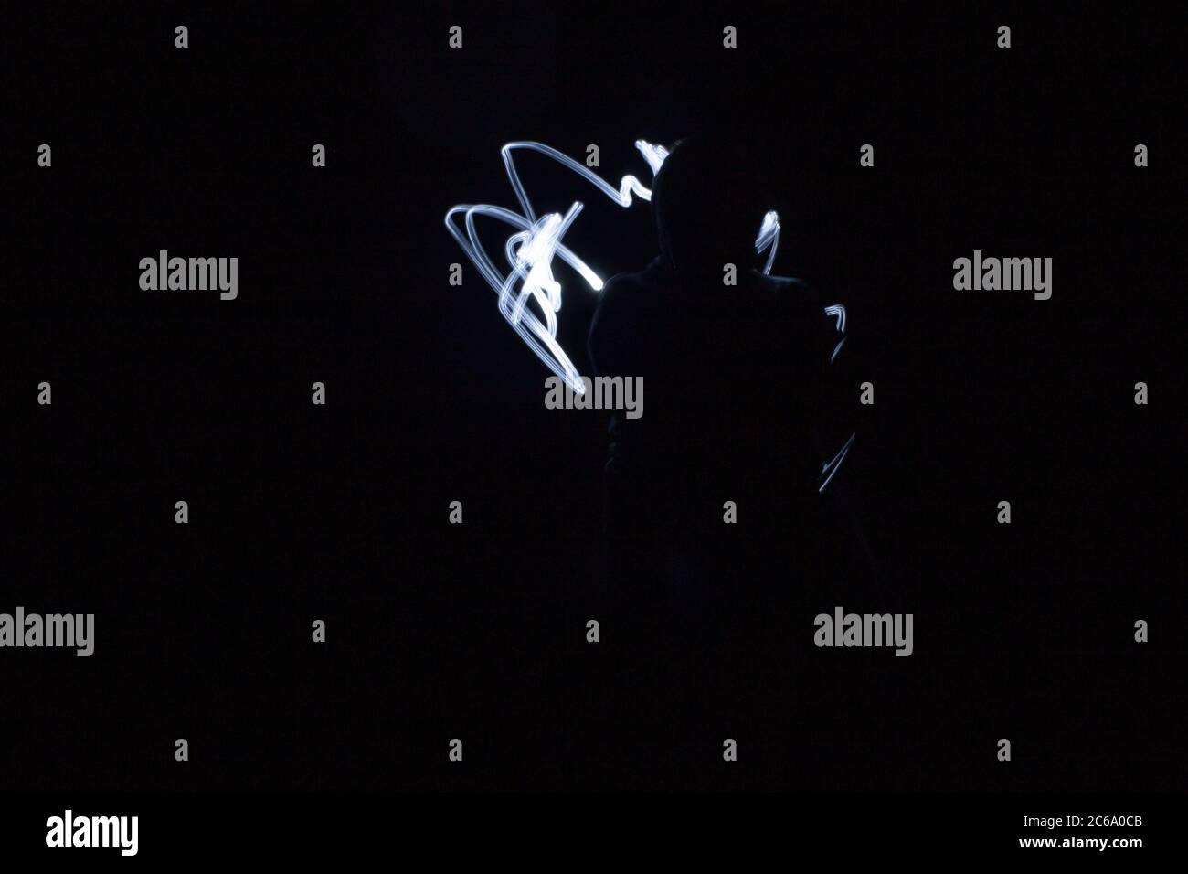 Lampe de poche dans la silhouette sombre et peinte par la lumière Banque D'Images