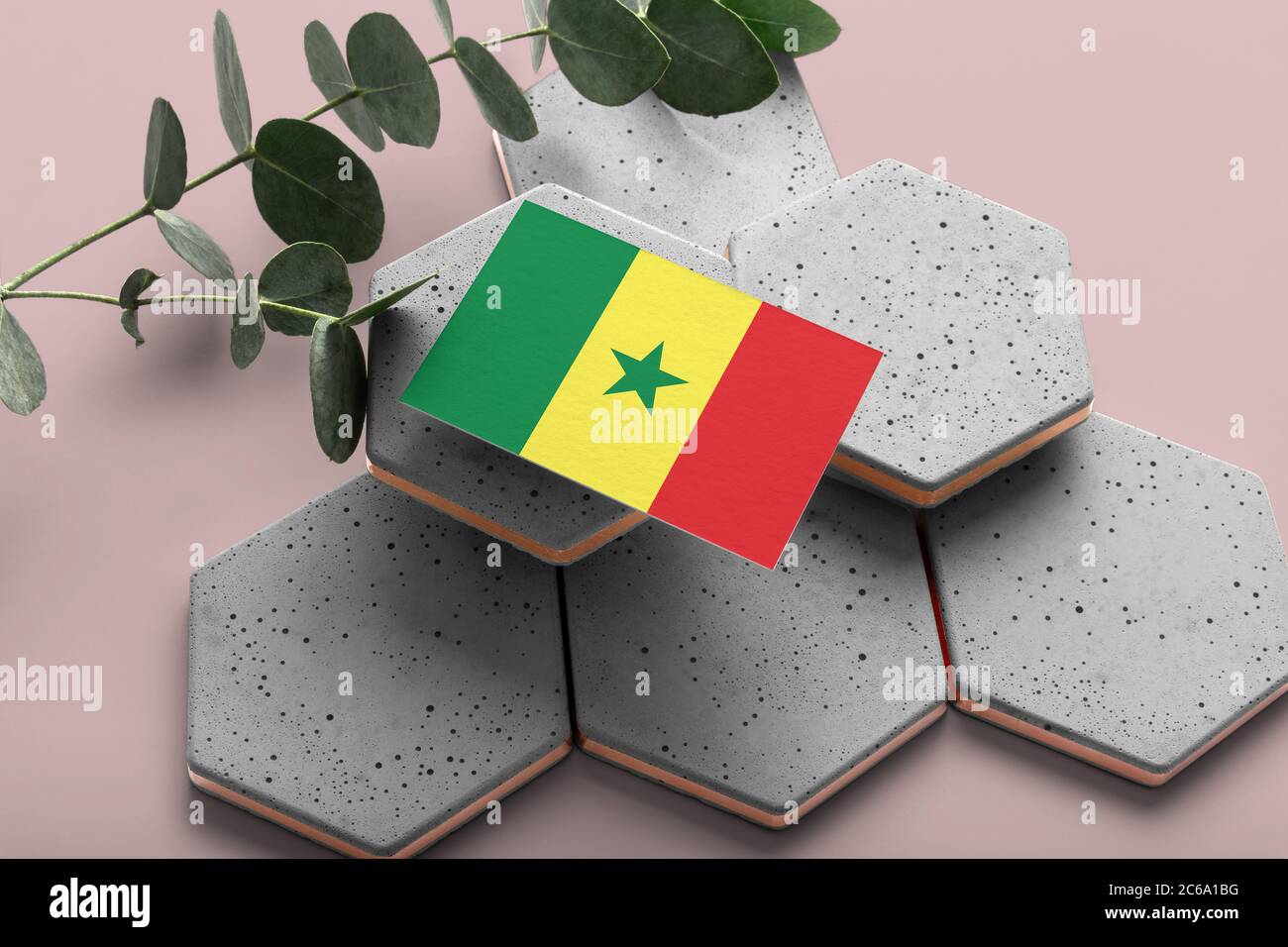Drapeau du Sénégal sur des pierres hexagonales stylées. Arrière-plan rose de l'espace de copie. Flat Lay, vue de dessus concept national minimal. Banque D'Images