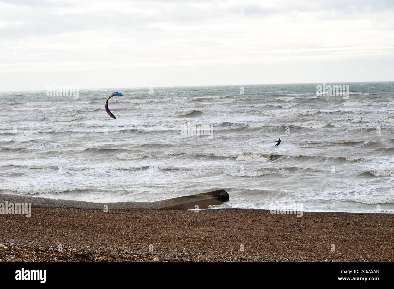 Kite Surfer à cheval sur les vagues près de la plage Banque D'Images
