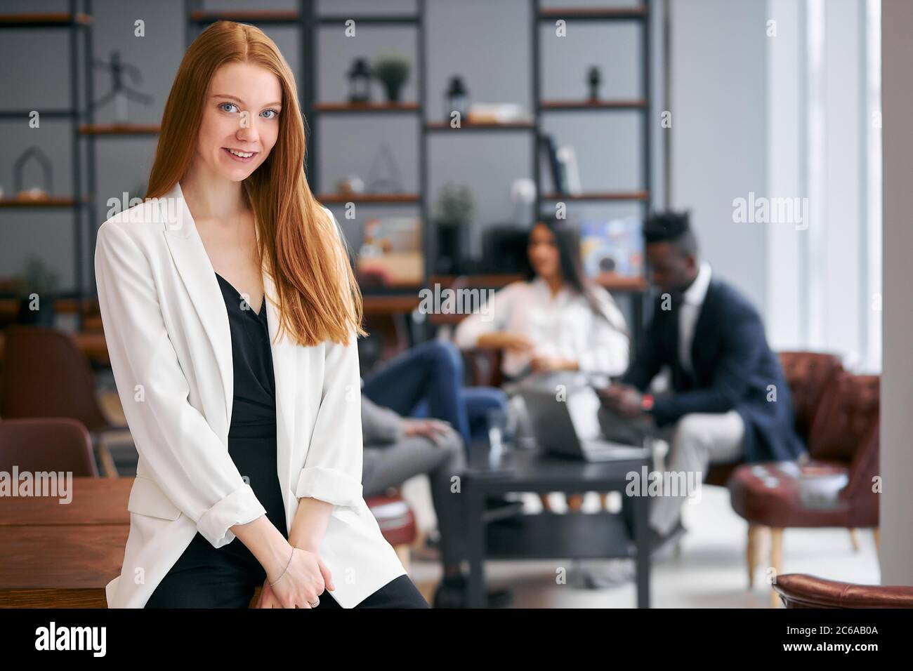 Belle femme avec un cheveu rouge regardant la caméra, posant à la caméra. Groupe international de partenaires commerciaux Banque D'Images