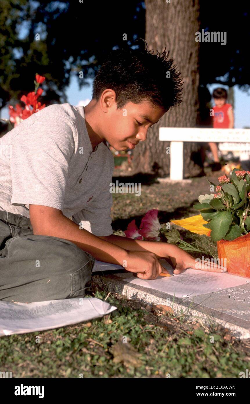 San Antonio, Texas 02 NOV 01: Frank Gonzalez, un grader de San Antonio, fait un frottement sur la pierre tombale de l'un de ses parents pendant la célébration Dia de Los Muertos 'Day of the Dead' au cimetière de San Fernando II. ©Bob Daemmrich Banque D'Images