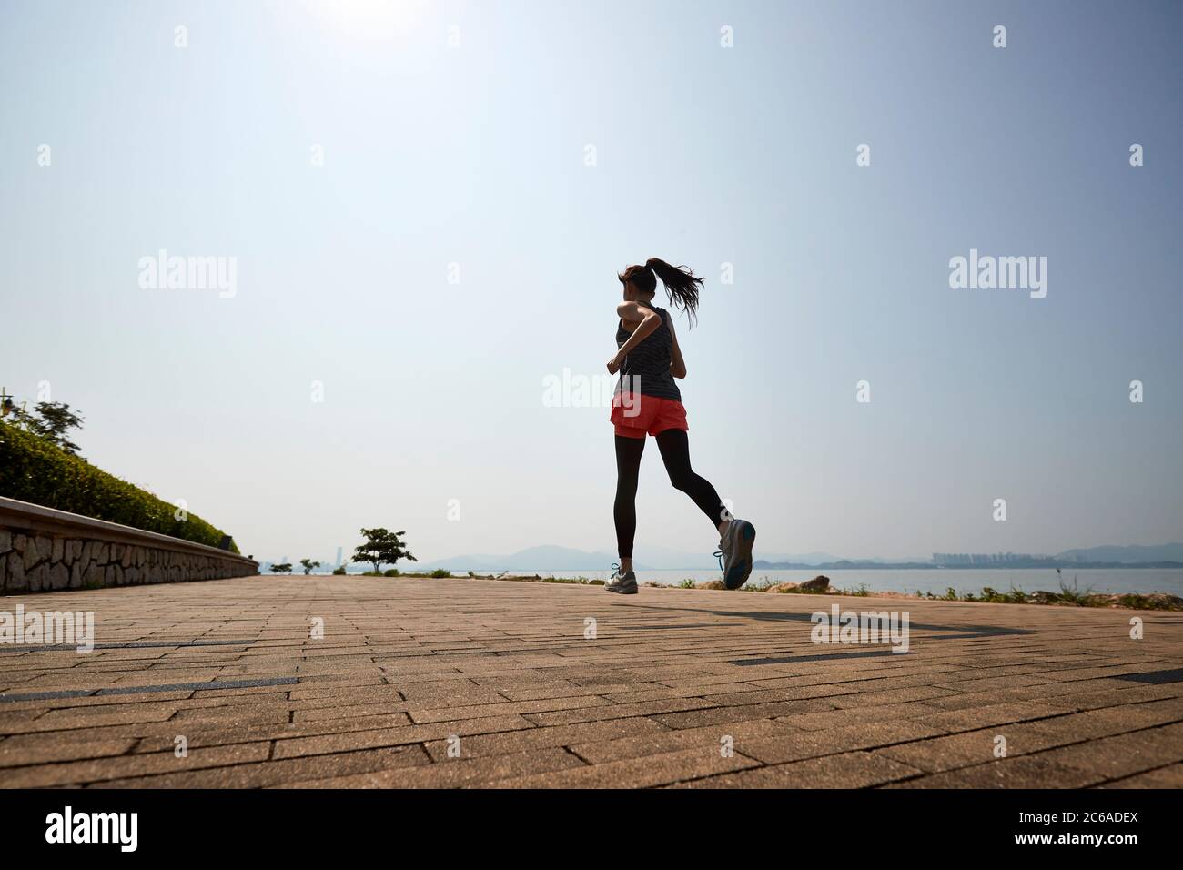 jeune femme adulte asiatique courir à l'extérieur Banque D'Images