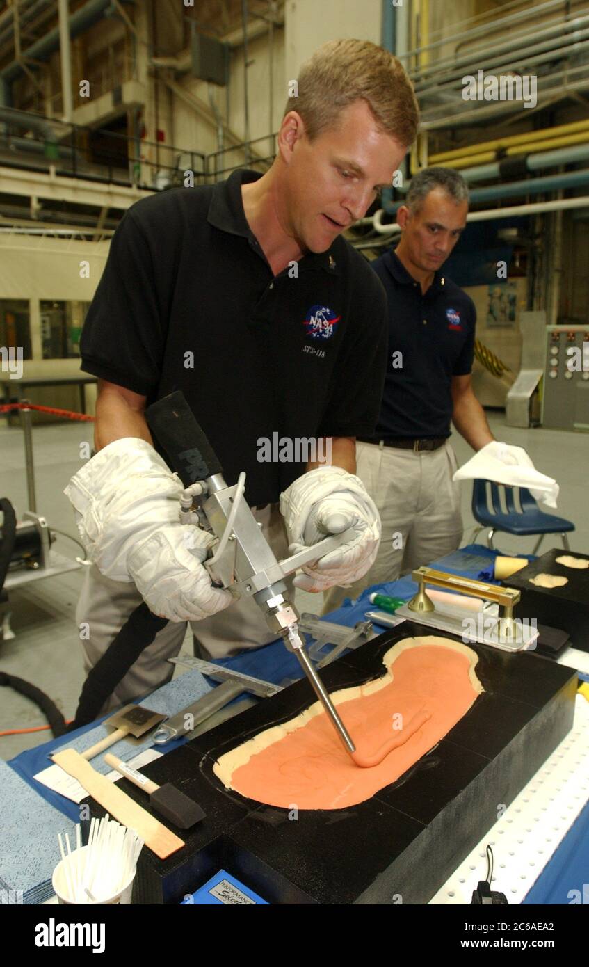 Houston Texas États-Unis, 16 septembre 2003 : au cours d'une tournée de presse au Johnson Space Center, l'astronaute de la NASA Scott Parazynski, qui participera à une prochaine mission de navette spatiale, montre comment le matériau de remplissage des tuiles sera utilisé pour combler les trous dans les tuiles de la navette spatiale par les astronautes effectuant une mission de réparation. La NASA prépare le retour en vol du programme de la navette spatiale en 2004, suite à la perte de la navette Columbia le 1 février. ©Bob Daemmrich Banque D'Images