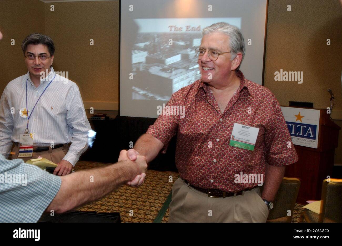Corpus Christi Texas USA, juin 2004: Un délégué de congrès masculin portant un nametag se serre la main après un programme d'éducation à une convention des propriétaires et des employés d'une entreprise d'assurance de titres fonciers du Texas. ©Bob Daemmrich Banque D'Images