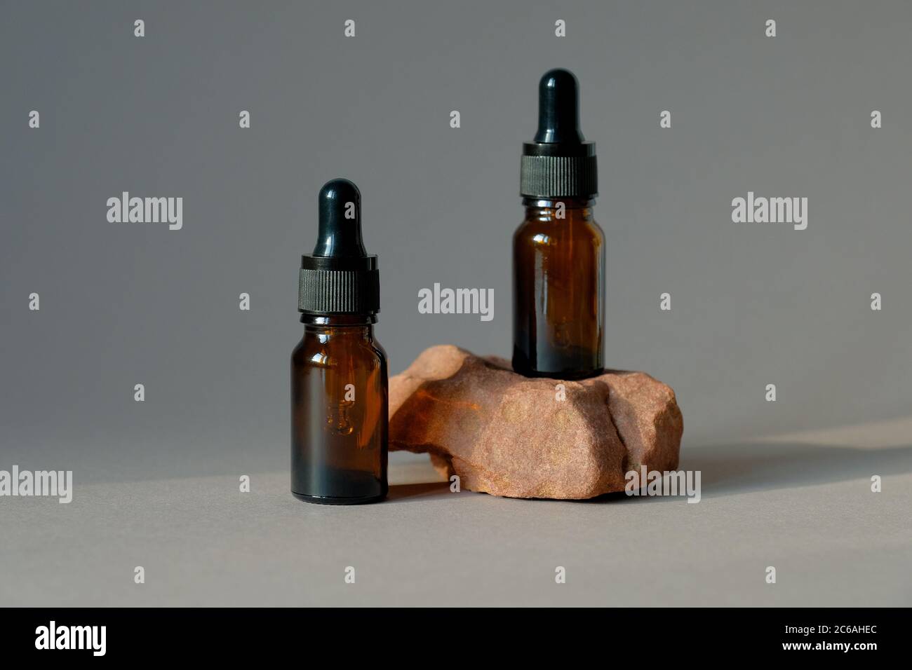 Maquette de flacons compte-gouttes en verre ambré foncé. Conception d'emballage à base d'huile essentielle biologique naturelle. Banque D'Images