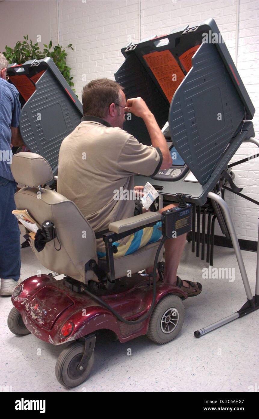 Austin, Texas États-Unis, 19 octobre 2004: Les électeurs précoces du Rebekah Baines Johnson (RBJ) Retirement Centre, un assis sur un fauteuil roulant motorisé devant un système de vote électronique, ont voté à l'élection générale de 2 novembre. ©Bob Daemmrich Banque D'Images