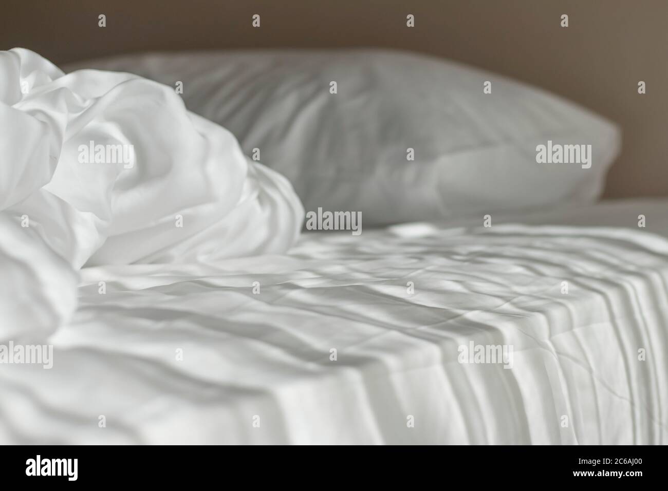 Matelas blanc le matin avec la lumière sur le lit. Banque D'Images