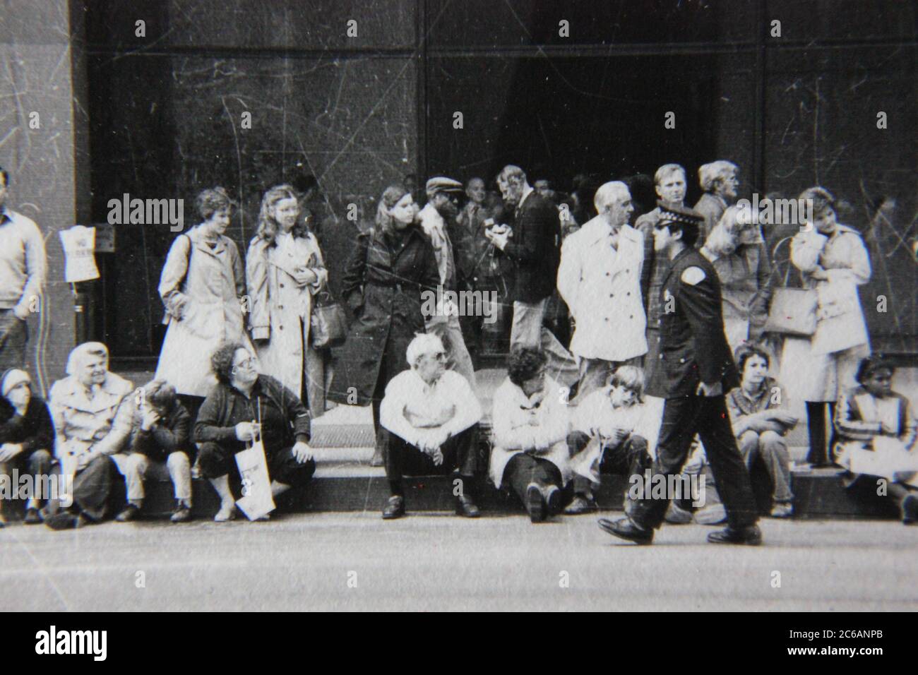 Fin années 70 vintage noir et blanc style de vie photographie d'une foule formant pour voir le défilé du centre-ville. Banque D'Images