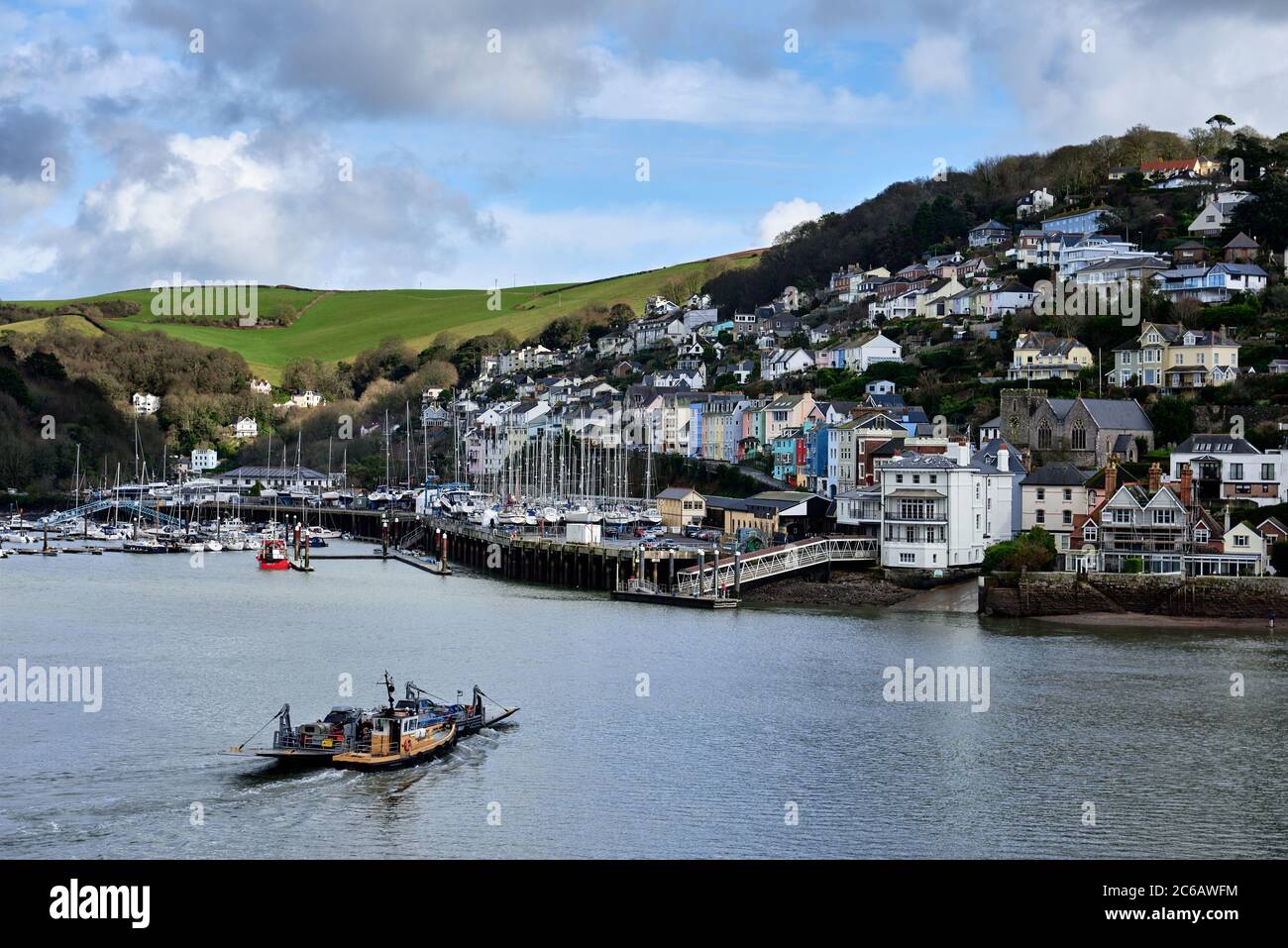 Ferry traversant la rivière Dart de Dartmouth à la ville de Kingjure, à flanc de colline, avec ses maisons peintes en couleurs. Banque D'Images