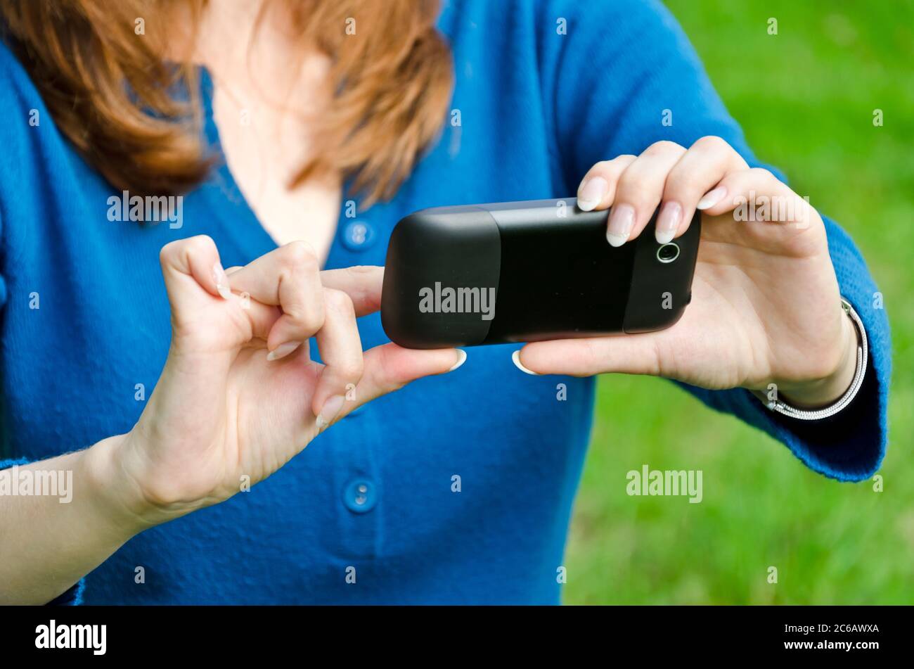 Jeune femme (visage non visible) utilisant son smartphone Banque D'Images