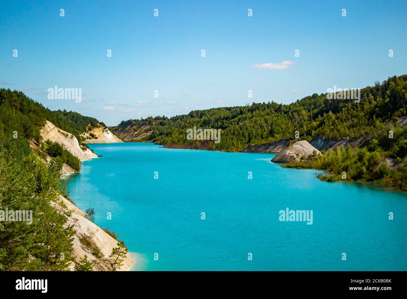 Lac inhabituel avec eau turquoise dans le cratère. Carrière de craie de la côte rocheuse au Bélarus. Jour d'été ensoleillé. Banque D'Images