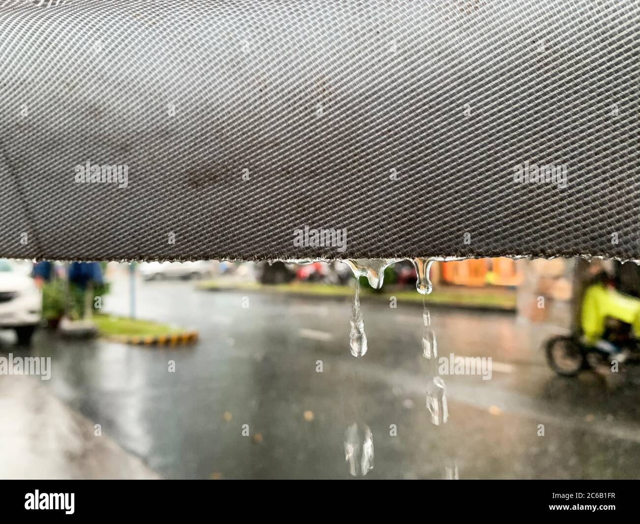 scènes de pluie, gouttes de pluie déchiquetées le long du bord d'une feuille de plastique, scènes de rue dans la pluie, et voitures floues derrière l'arrière-plan. Moody et Weath Banque D'Images