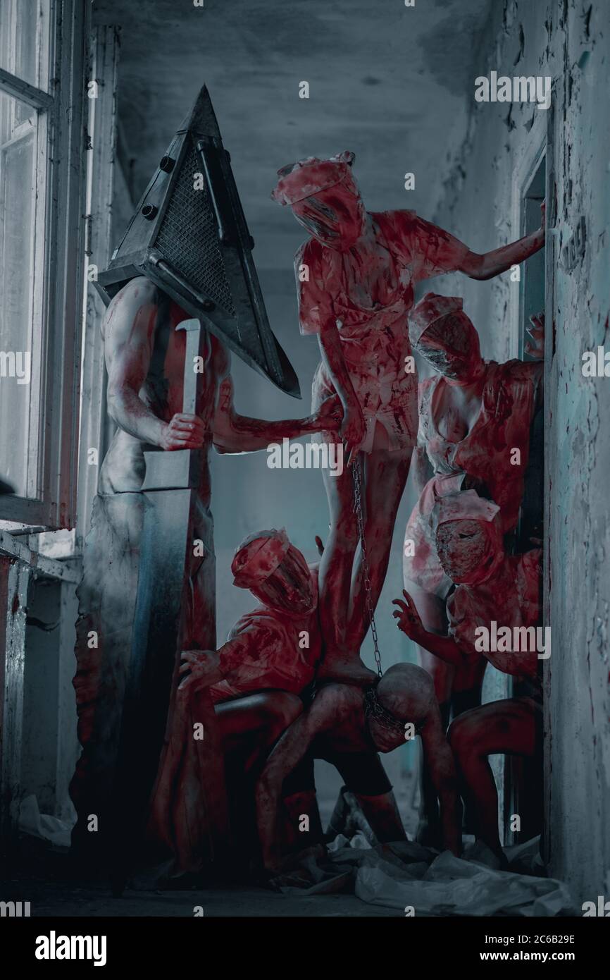 Les cojoueurs à l'image de monstres sanglants et bourreau sont dans la  pièce sombre Photo Stock - Alamy