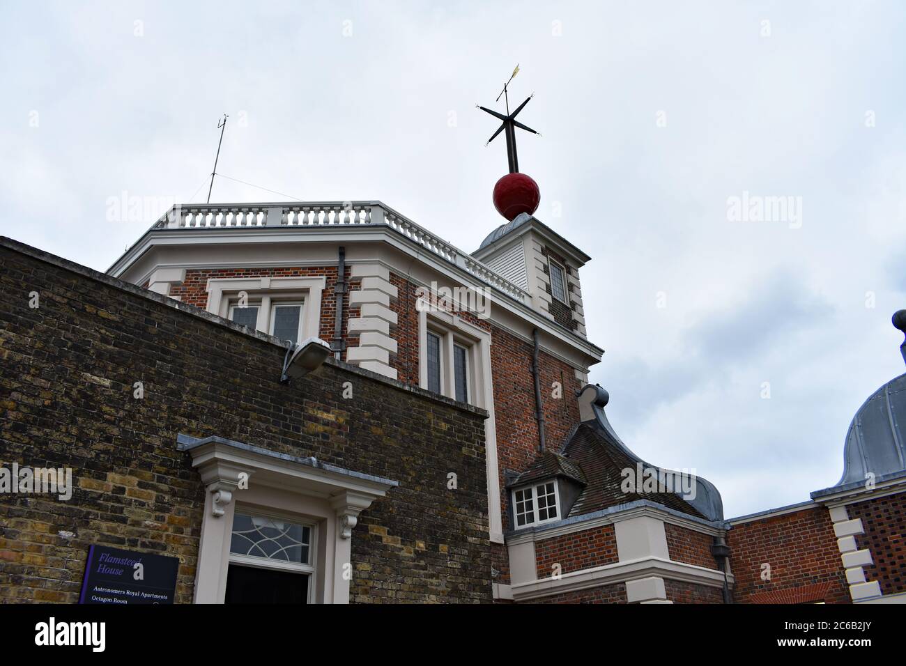 Par une journée nuageux, vous pouvez observer le ballon de nuit rouge et la girouette au-dessus de la salle Octagon et de la maison à feu de flamme à l'Observatoire royal de Greenwich Park Banque D'Images