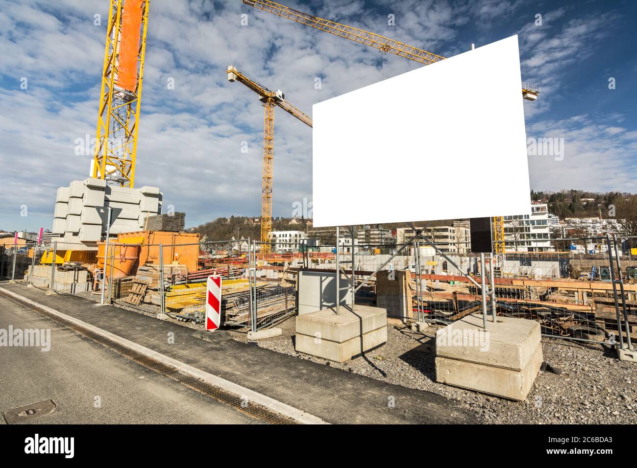 Panneau d'affichage vierge sur un chantier de construction avec grues Banque D'Images