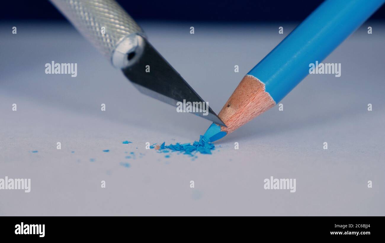 Personne âgée aiguisez un crayon de couleur à l'aide d'un petit couteau pointu Banque D'Images