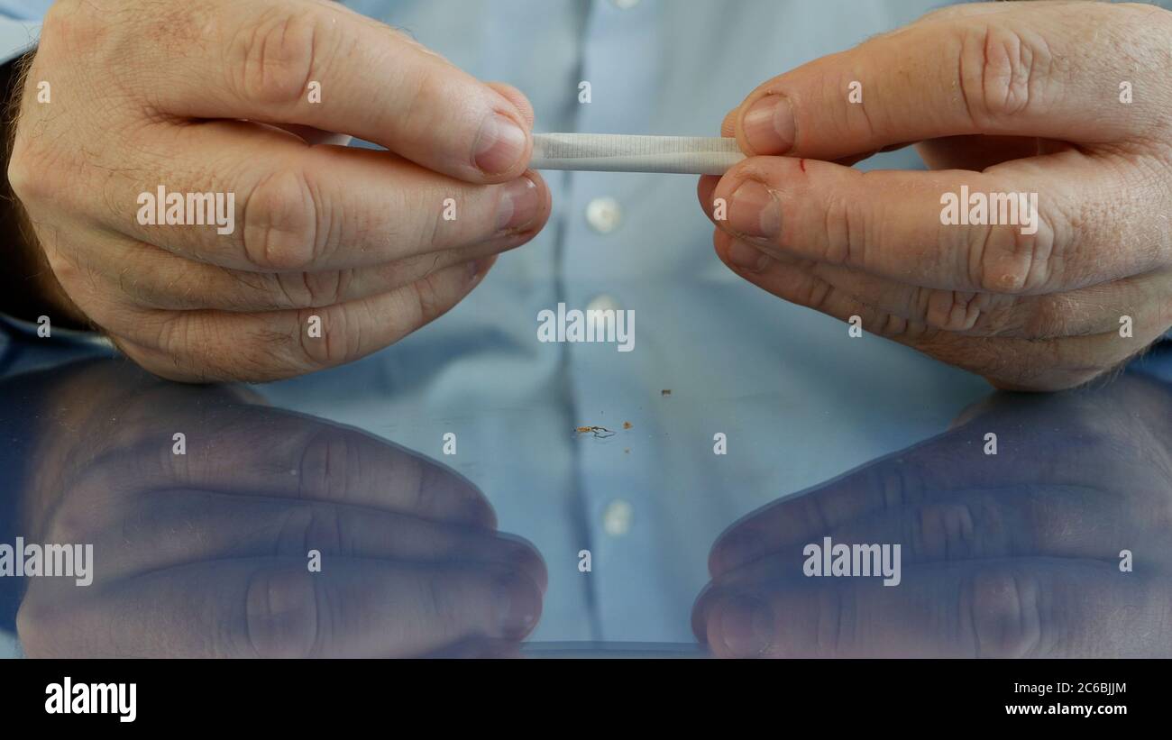 Fume rouler une cigarette faite à la main en utilisant du papier à cigarettes un filtre et du tabac Banque D'Images